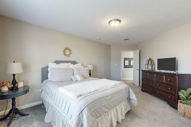 bedroom featuring a textured ceiling and light colored carpet