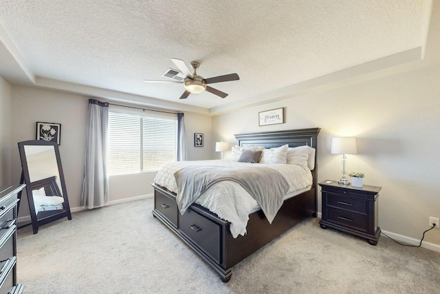 carpeted bedroom featuring ceiling fan, a textured ceiling, and a raised ceiling