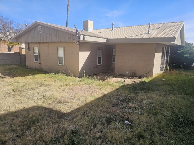 rear view of property featuring a yard