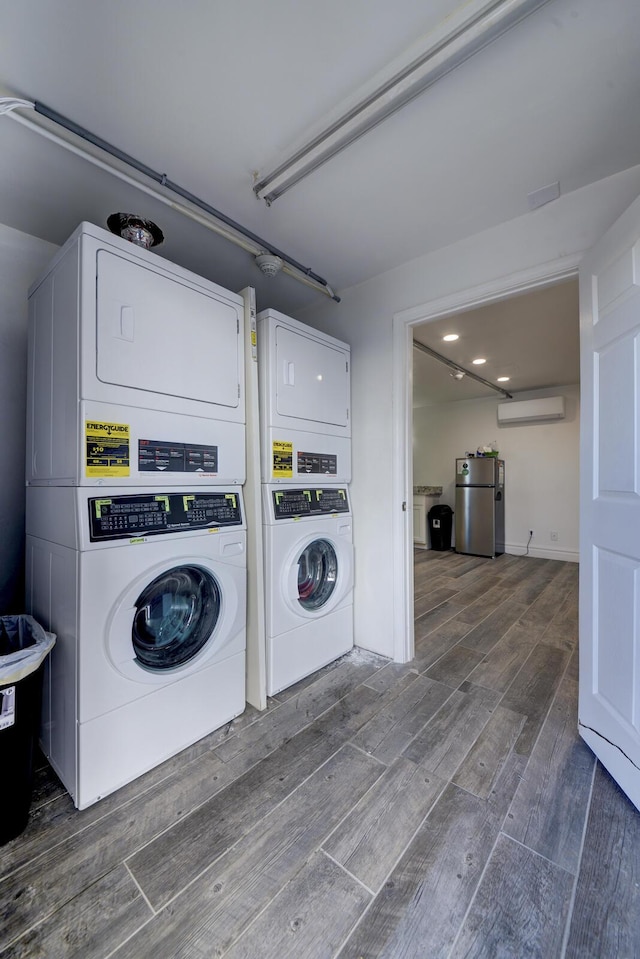 laundry area with stacked washer / dryer and an AC wall unit