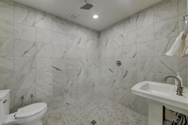 bathroom featuring toilet, a shower, tile walls, and sink