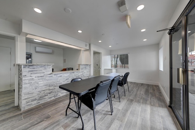 dining space featuring an AC wall unit and plenty of natural light