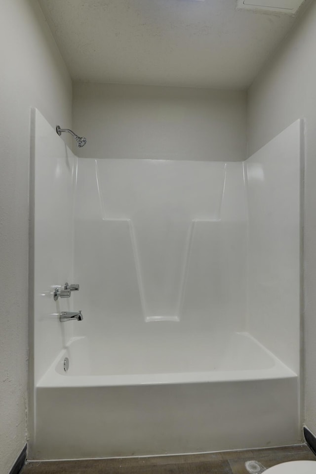 bathroom with toilet and bathing tub / shower combination