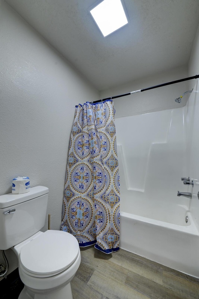 bathroom featuring hardwood / wood-style flooring, toilet, and shower / bath combo with shower curtain