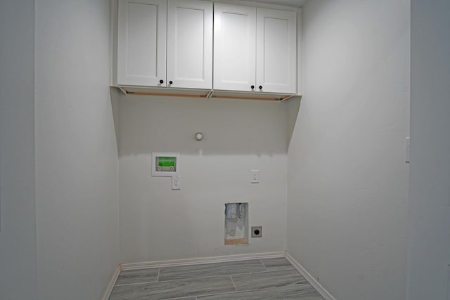 clothes washing area featuring washer hookup, cabinets, gas dryer hookup, and electric dryer hookup