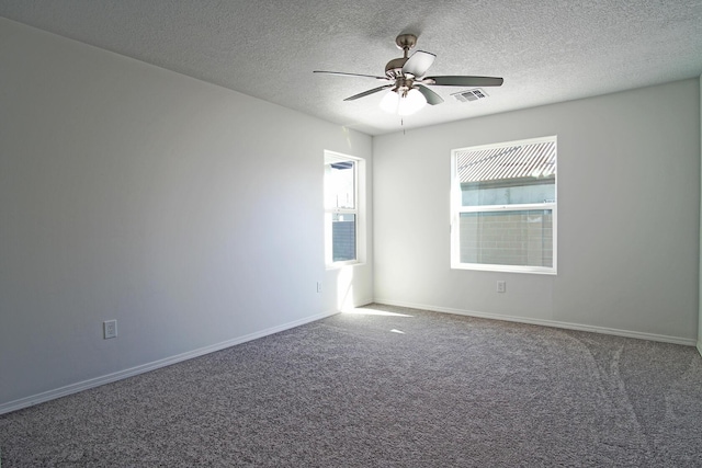 unfurnished room with carpet, ceiling fan, and a textured ceiling