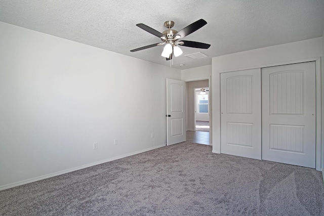 unfurnished bedroom with a textured ceiling, ceiling fan, carpet flooring, and a closet