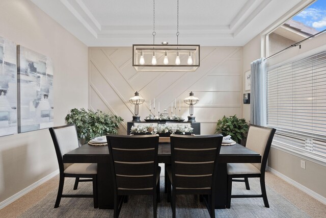 dining area with carpet and a raised ceiling