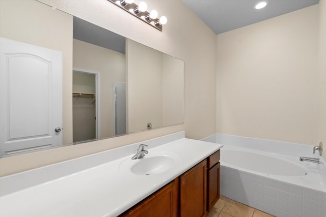 bathroom with vanity, tiled bath, and tile patterned flooring