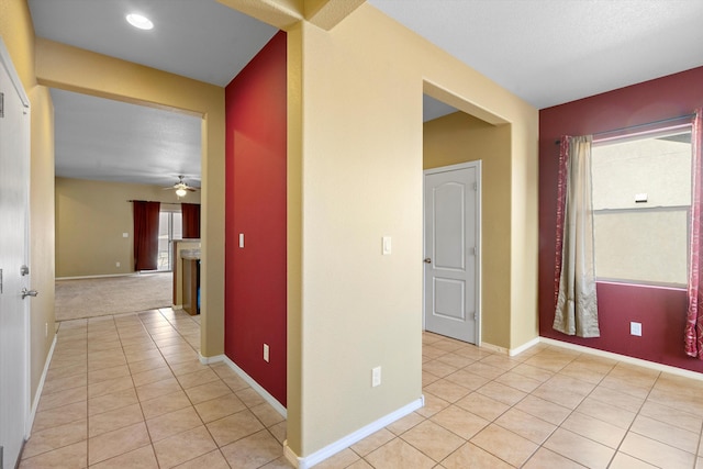 hallway featuring a wealth of natural light and light tile patterned floors