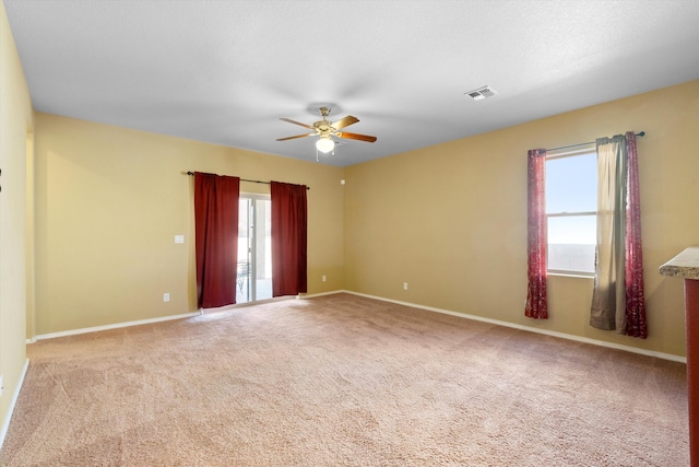 carpeted spare room with ceiling fan