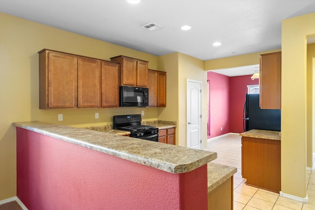 kitchen with black appliances, kitchen peninsula, and light tile patterned flooring