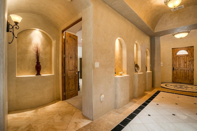 foyer with brick ceiling and lofted ceiling