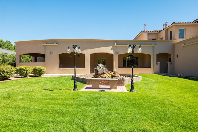 back of house with a lawn and a patio