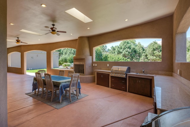 view of patio with ceiling fan, area for grilling, exterior kitchen, and sink