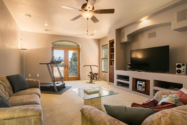 living room with carpet floors, french doors, built in features, and ceiling fan