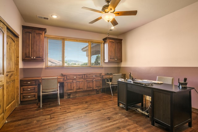 office area with ceiling fan, dark hardwood / wood-style flooring, and built in desk