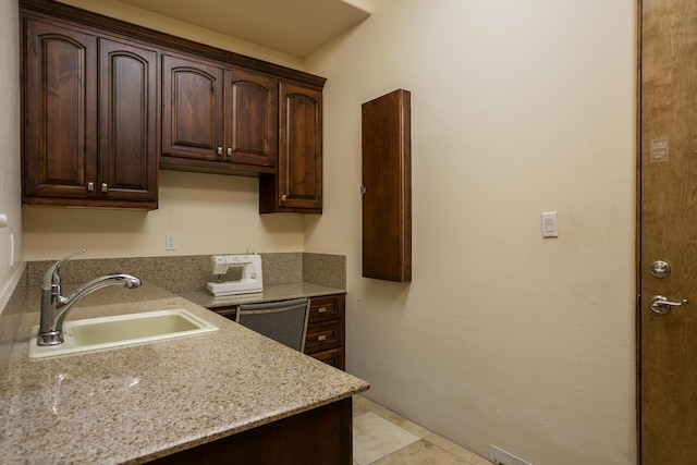 kitchen with sink, dishwasher, and dark brown cabinets