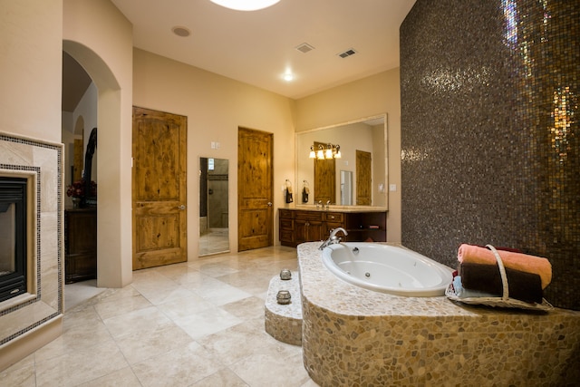 bathroom with tiled tub and vanity