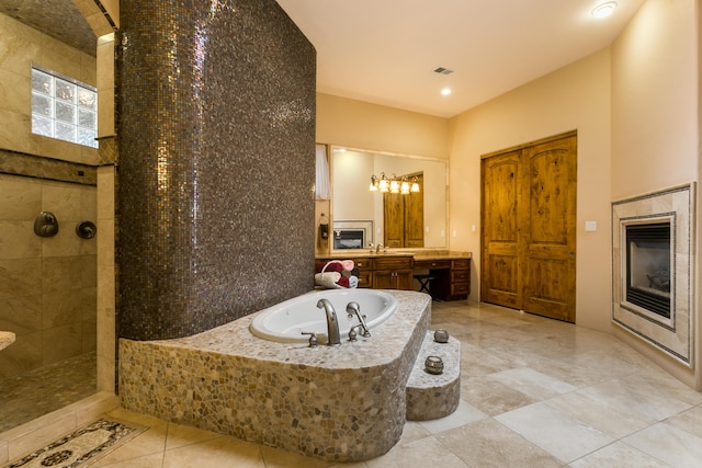 bathroom featuring vanity and independent shower and bath