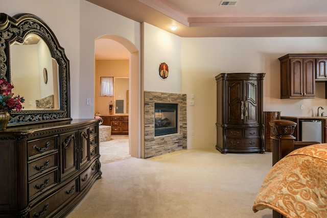 bedroom featuring light carpet and a tile fireplace