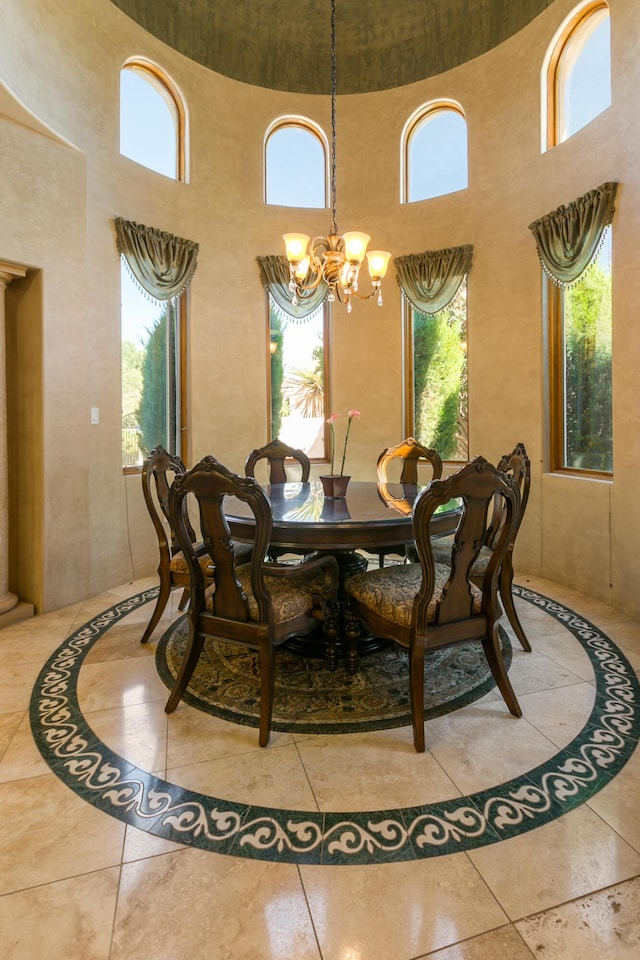 dining space with a towering ceiling and a notable chandelier