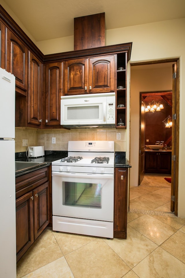 kitchen with white appliances, light tile patterned floors, dark stone counters, and tasteful backsplash