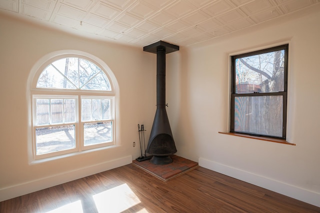 unfurnished living room featuring a wood stove and hardwood / wood-style floors