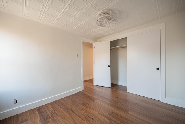 unfurnished bedroom with a closet and dark hardwood / wood-style flooring