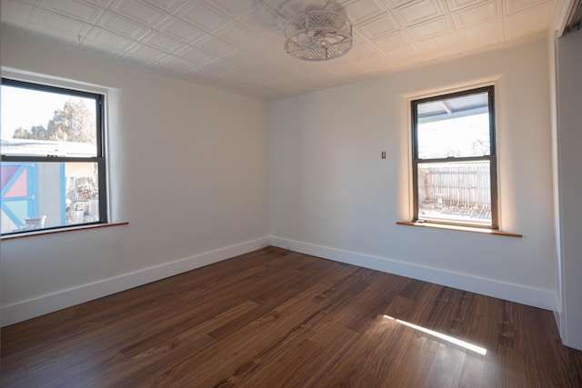 unfurnished room featuring dark wood-type flooring and a wealth of natural light