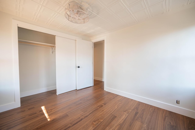 unfurnished bedroom with a closet and dark hardwood / wood-style flooring