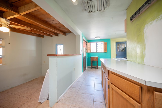 kitchen with beamed ceiling and light tile patterned flooring