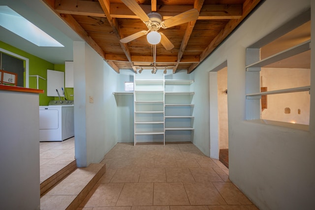 hallway with separate washer and dryer, a skylight, wood ceiling, and rail lighting