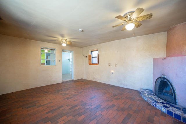 unfurnished living room with ceiling fan