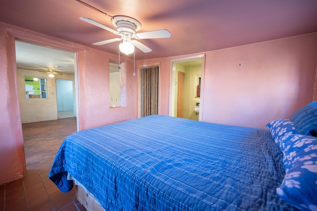 bedroom featuring ceiling fan, connected bathroom, and dark tile patterned flooring