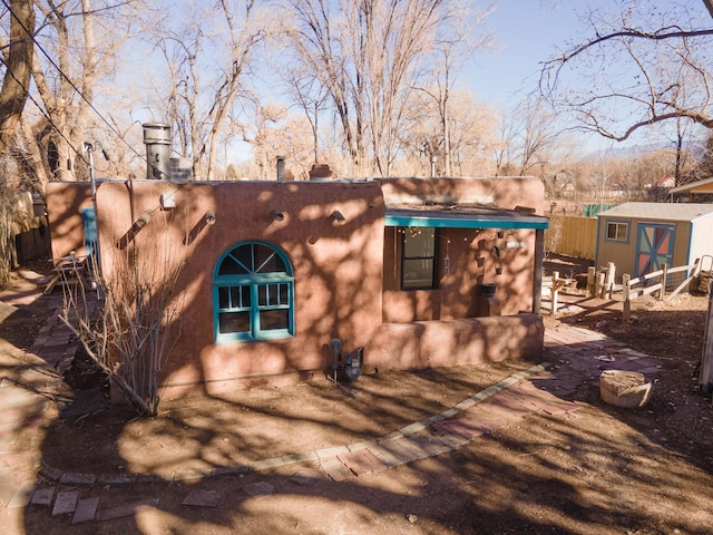 back of property featuring a storage shed