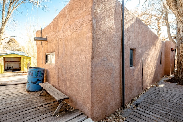 view of side of home with a deck and an outbuilding