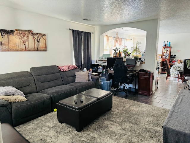 tiled living room featuring a textured ceiling