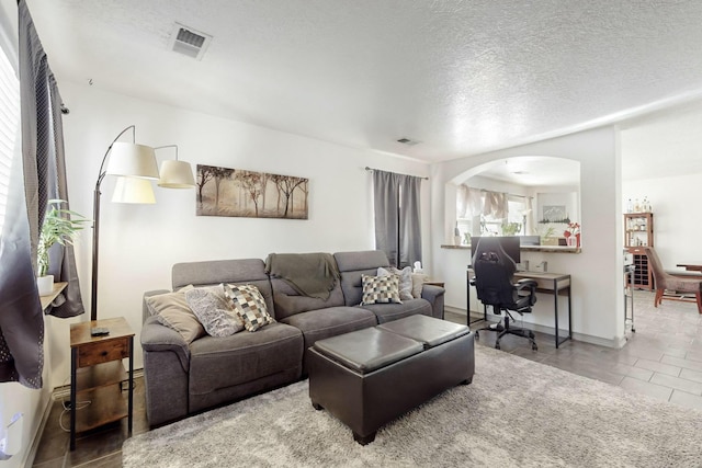 tiled living room with a textured ceiling