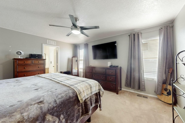 carpeted bedroom featuring a textured ceiling and ceiling fan