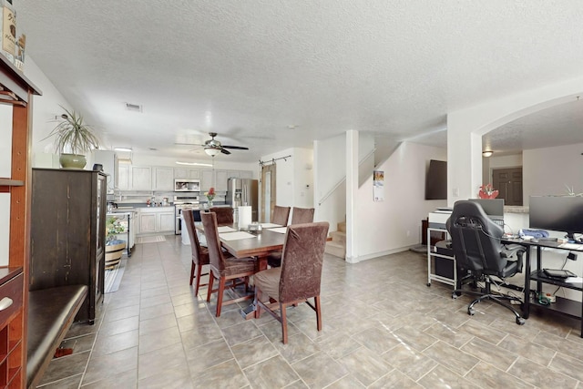 tiled dining room featuring ceiling fan and a textured ceiling