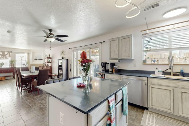 kitchen with sink, a wealth of natural light, dishwasher, and a kitchen island