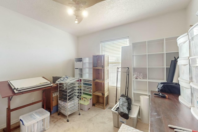 carpeted office featuring a textured ceiling