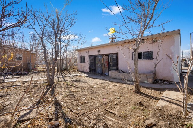 rear view of house featuring a storage unit