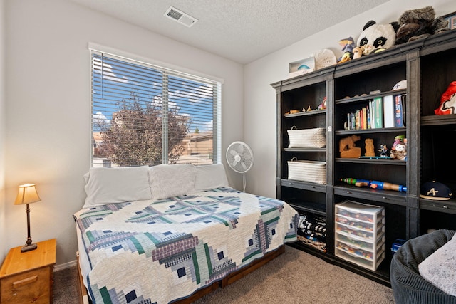 bedroom featuring dark colored carpet and a textured ceiling