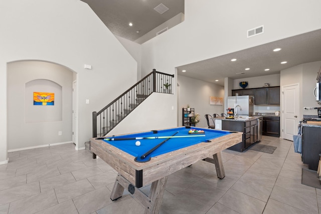 recreation room with pool table, sink, light tile patterned floors, and a high ceiling