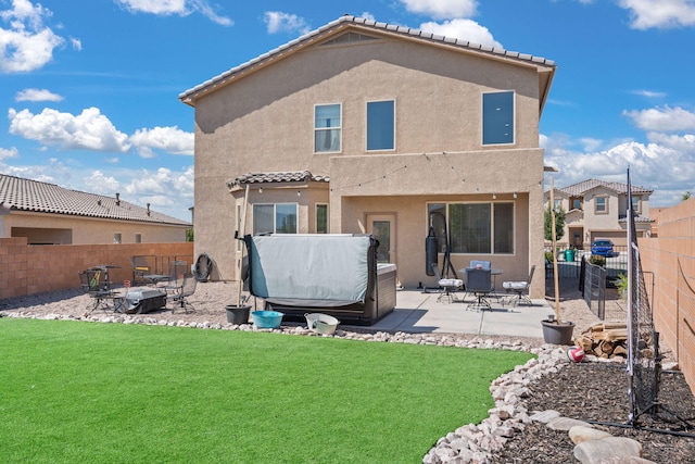 back of house featuring a patio and a lawn