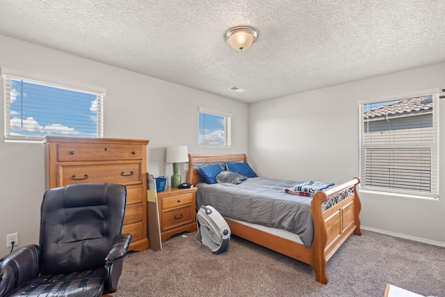 bedroom with light carpet and a textured ceiling