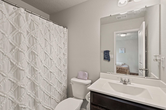 bathroom with vanity, a textured ceiling, and toilet