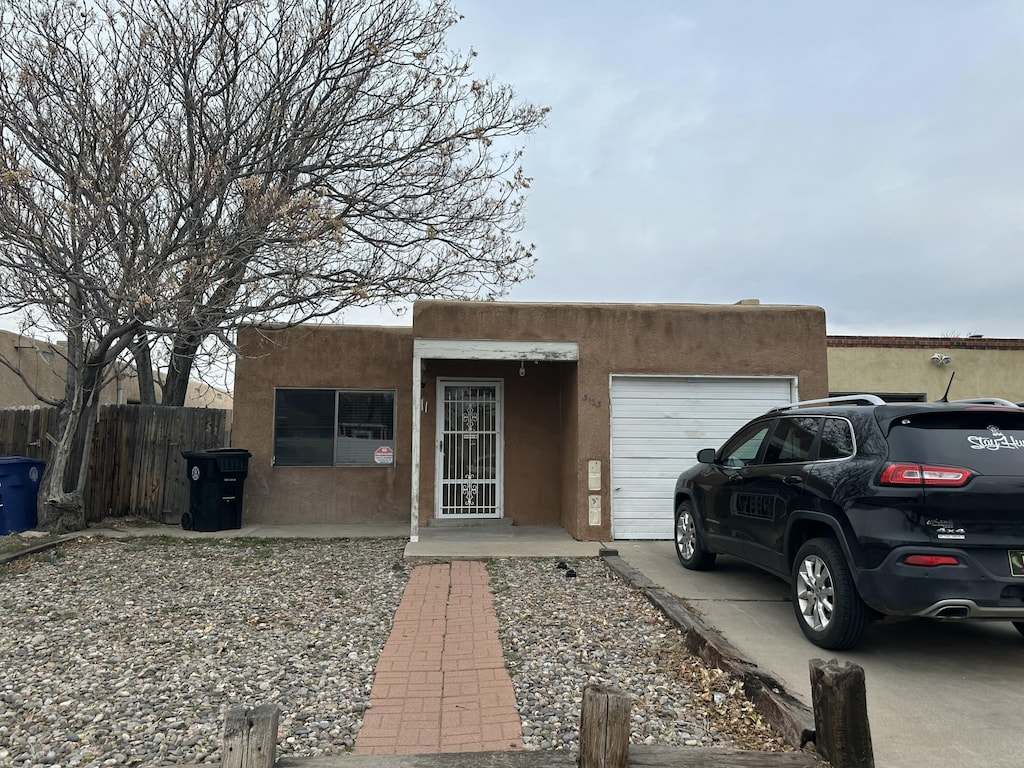 pueblo revival-style home with a garage